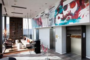 a living room with a large painting on the wall at Hotel Indigo Berlin - East Side Gallery by IHG in Berlin