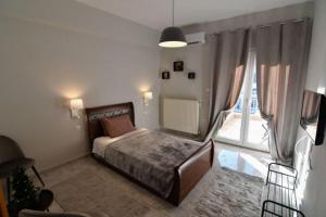 ein Schlafzimmer mit einem Bett und einem großen Fenster in der Unterkunft Kostaras Comfort Stay in Dispilio