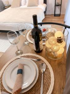a table with a plate and a bottle of wine at LUMO Terrace Studio with Private Parking near Coresi in Braşov
