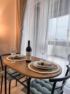 a table with a bottle of wine and two glasses at LUMO Terrace Studio with Private Parking near Coresi in Braşov