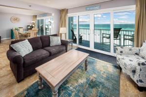 een woonkamer met een bank en een tafel bij Islander FWB 501 Spacious gulf front condo in Fort Walton Beach