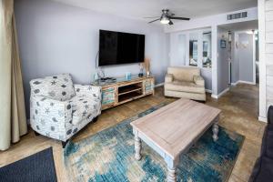 een woonkamer met een bank en een tv bij Islander FWB 501 Spacious gulf front condo in Fort Walton Beach