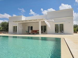 奥斯图尼Borgo Cervarolo的一座白色的房子,前面设有一个游泳池