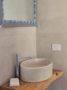 奥斯图尼Borgo Cervarolo的浴室里有一个石浴缸，浴缸放在木质台面上。