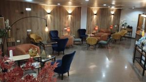 a waiting room at a salon with chairs and tables at Hotel Alnacir in Faro