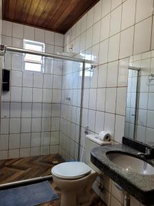 a bathroom with a toilet and a sink at Pousada Raízes na Vila de Barra Grande in Marau
