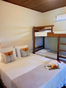two beds in a room with two bunk beds at Pousada Raízes na Vila de Barra Grande in Marau