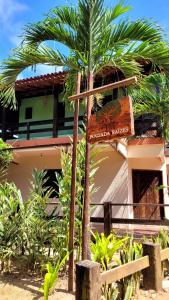 a palm tree with a sign in front of a building at Pousada Raízes na Vila de Barra Grande in Marau