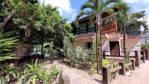 a building with trees and plants in front of it at Pousada Raízes na Vila de Barra Grande in Barra Grande