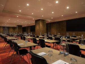 una sala de conferencias con mesas, sillas y una pantalla en SO/ Auckland, en Auckland 178 fotos más