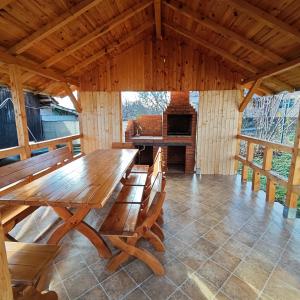 einen Holztisch und Stühle in einer Hütte mit Kamin in der Unterkunft Casa Noastra in Drajna de Sus