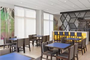 ナッシュビルにあるGLo Best Western Nashville Airportのテーブルと椅子と窓のあるダイニングルーム