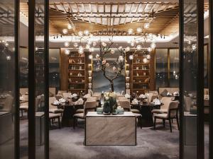 Un comedor con mesas y sillas y una lámpara de araña. en Pullman Fuzhou Tahoe, en Fuzhou