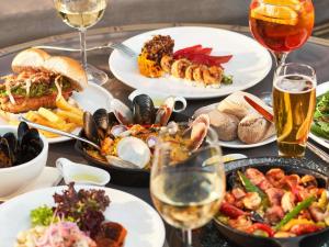 una mesa con platos de comida y copas de vino en Pullman Vina del Mar San Martin, en Viña del Mar