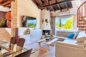 un soggiorno con un divano e un tavolo di Villa Claire 10-Acre Private Estate with Pool near Corfu Old Town a Gastouri