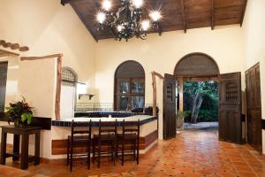 Una cocina con una isla central con taburetes de bar. en Hacienda Barrigona, en Sámara 19 fotos más