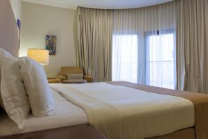 Ένα ή περισσότερα κρεβάτια σε δωμάτιο στο Al Qurum Resort