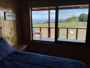 a bedroom with a bed and a window with a view at Chiloé,Curaco de Velez casa de veraneo in Curaco de Velez
