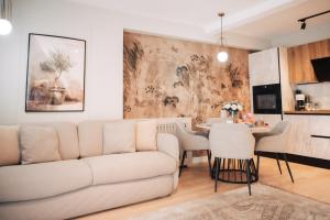 een woonkamer met een bank en een tafel bij Harmony North Two Bedroom in Boekarest