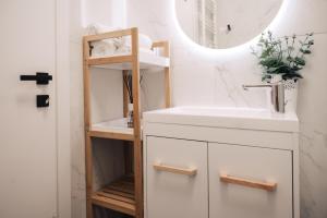 een badkamer met een wastafel en een spiegel bij Harmony North Two Bedroom in Boekarest +48 foto's