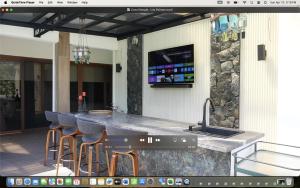 a kitchen with a bar with stools and a sink at Casa Mangle in Tela