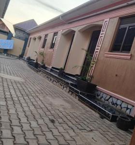 eine Reihe von Häusern mit Topfpflanzen auf einer Straße in der Unterkunft OnlineGuest House Katete in Mbarara