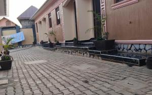 einen Innenhof mit Topfpflanzen an der Seite eines Gebäudes in der Unterkunft OnlineGuest House Katete in Mbarara