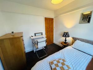 ein Schlafzimmer mit einem Bett und einem Schreibtisch in der Unterkunft The Norbury Hill Residence in West Norwood + 7 Fotos