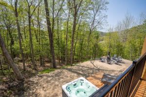 a hot tub on a deck in the woods at Chalet Le Greenwood - Mountain View & Private Spa in Saint-Faustin