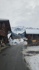 una calle frente a una montaña cubierta de nieve en Alphenrose saxeten, en Saxeten
