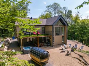 a house with a boat in front of it at Le Greenwood 2 - Sauna - Spa - Mountain View in Saint-Faustin