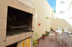 ein Balkon mit Tisch und Stühlen sowie einem großen Kamin in der Unterkunft Lucaya in Miramar + 5 Fotos