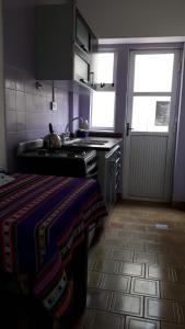 eine Küche mit einem Herd, einem Waschbecken und einem Fenster in der Unterkunft Lucaya in Miramar