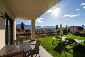 een terras met een tafel en stoelen en een gazon bij Weingut Gasshof in Appiano sulla Strada del Vino