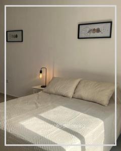 una camera con un letto bianco e un piumone bianco di El Rinconcito del Centro a Concepción del Uruguay