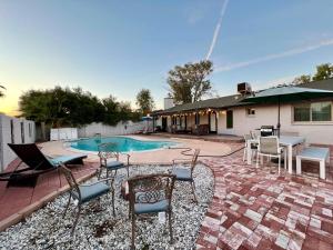 a patio with chairs and a table and a pool at Tempe Escape with Heated Pool, Billiards & Firepit Fun in Tempe