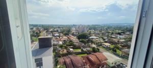 Blick auf eine Stadt aus einem Fenster in der Unterkunft Apartamento mobiliado próximo Unesc em Criciúma in Criciúma