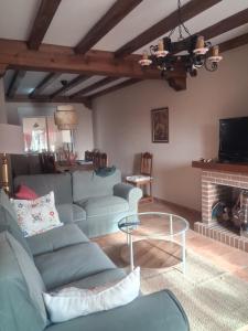 ein Wohnzimmer mit Sofa und Kamin in der Unterkunft Casa Guinda in Gavilanes