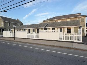 旧奥查德比奇Moontide Motel, Apartments, and Cabins的房子前面的白色栅栏