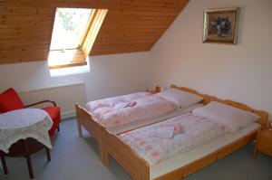 a bedroom with two beds and a table and a window at Penzion Javořice in Telč