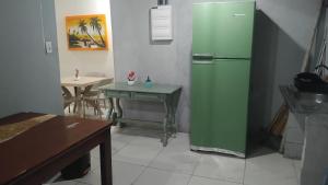 un frigorifero verde in una cucina con tavolo di Pousada a São Vicente