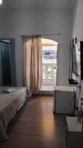 una camera da letto con un letto e una grande finestra di Pousada a São Vicente