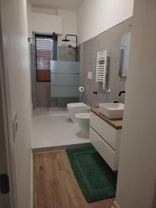 een badkamer met 2 toiletten, een wastafel en een spiegel bij Oltremare in Molfetta