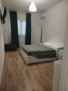 een slaapkamer met een bed en een houten vloer bij Oltremare in Molfetta