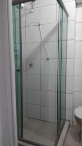 una doccia con una porta in vetro in un bagno di Pousada a São Vicente Altre 98 foto
