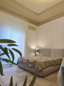 a bedroom with a bed and a large window at Visconti apartment and Spa in Catania