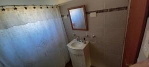 a bathroom with a sink and a shower curtain at El Chalten hospedaje diario in General Pico +2 photos