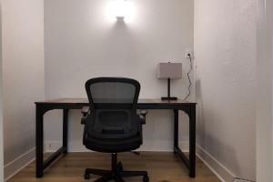 ein Schreibtisch mit einem Stuhl und einer Lampe in einem Zimmer in der Unterkunft The Belmont at PWC in Hot Springs