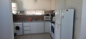 a kitchen with a white refrigerator and a sink at El Chalten hospedaje diario in General Pico