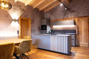 a kitchen with a counter and a table with chairs at Schulhaus Tirol in Zell am Ziller